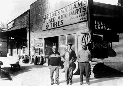 Louis, son, and grandson in front of 1932 storefront
